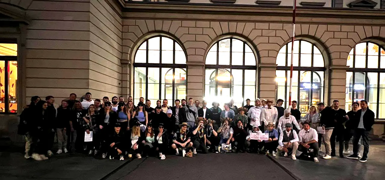 Grosse Gruppe von Spielerinnen und Spielern, teils verkleidet, vor dem Hauptbahnhof Winterthur am Abend.